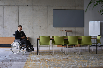 Image showing Businessman in a wheelchair in a modern office lonely after a busy day