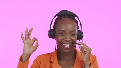 Image showing Business woman, call center and okay for communication, happy sales and excellence in customer service on a pink background. Portrait of African consultant in headphones, yes and contact us in studio