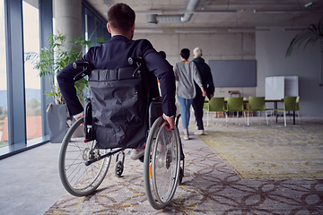 Image showing A diverse group of business professionals, including an person with a disability, gathered at a modern office for a productive and inclusive meeting.