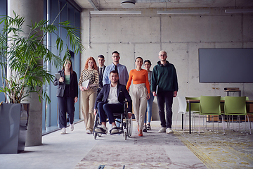Image showing A diverse group of businessmen, including a businessman in wheelchair, confidently stride together through a modern, spacious office, epitomizing collaboration, inclusivity, and strength in unity