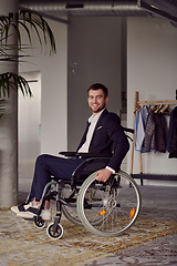 Image showing Businessman in a wheelchair commands attention, symbolizing resilience and success amidst a dynamic modern office environment.