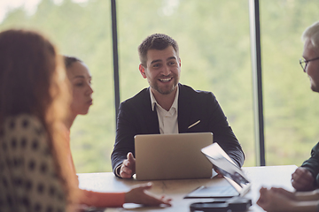 Image showing A diverse group of business professionals gathered at a modern office for a productive and inclusive meeting