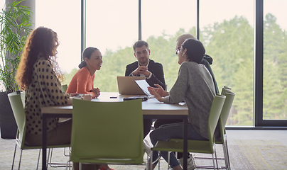 Image showing A diverse group of business professionals gathered at a modern office for a productive and inclusive meeting