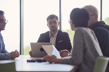 Image showing A diverse group of business professionals gathered at a modern office for a productive and inclusive meeting