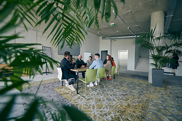 Image showing A diverse group of business professionals gathered at a modern office for a productive and inclusive meeting