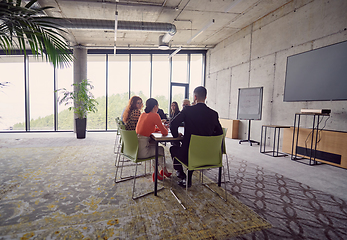 Image showing A diverse group of business professionals gathered at a modern office for a productive and inclusive meeting