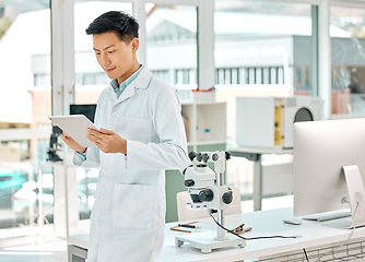 Image showing Working hard to find an efficient cure. a young scientist using a digital tablet in a lab.