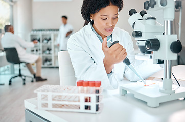 Image showing Lets get down to science. a young scientist working with samples while using a microscope in a lab.