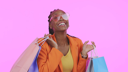 Image showing Woman, shopping bag and sunglasses for fashion sale, discount and giveaway prize or competition in studio. Portrait of african person or excited customer with gift or funky style on pink background