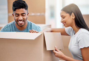 Image showing Where should we put this. a young couple unpacking boxes together in their new home.