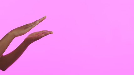 Image showing Hands, skincare and mockup with a person on a pink background in studio for advertising or marketing. Beauty, banner and space with a model closeup on a color wall for a salon or spa success