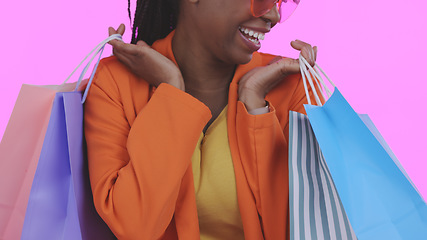 Image showing Woman, happy with shopping bag and retail, commerce and fashion, sale or store discount on pink background. Customer with purchase, market and luxury with service, excited about savings in studio