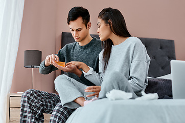 Image showing Making the journey to recovery a joint one. a young couple taking medication while recovering from an illness in bed at home.