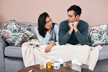 Image showing Self quarantine can lead to feelings of stagnation. a young couple sitting on the sofa while recovering from an illness at home.