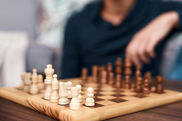 Image showing One move makes all the difference. an unrecognisable man playing a game of backgammon at home.