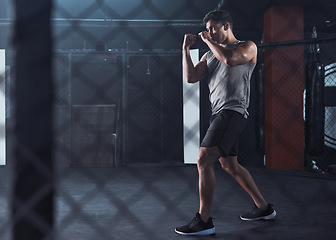 Image showing Fight for the fitness you deserve. a young man practicing his kickboxing routine at a gym.