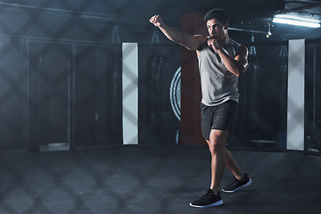 Image showing Health is power. a young man practicing his kickboxing routine at a gym.