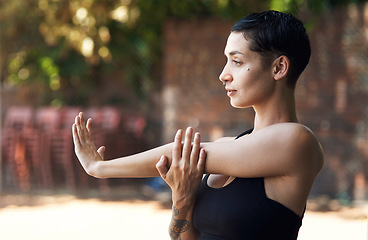 Image showing Limbering up for the game. an attractive young female athlete stretching while standing on the basketball court.