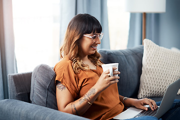 Image showing Coffee and wifi is all I need today. a young woman using her laptop while relaxing at home.