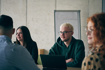 Image showing A diverse group of business professionals gathered at a modern office for a productive and inclusive meeting