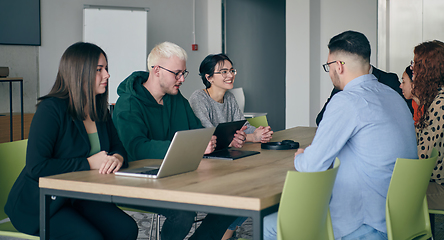 Image showing A diverse group of business professionals gathered at a modern office for a productive and inclusive meeting