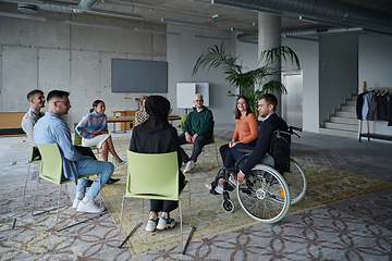 Image showing In a modern office, a diverse group of business individuals is seen gathered in a circle, engaged in lively discussions and sharing ideas about various business concepts.