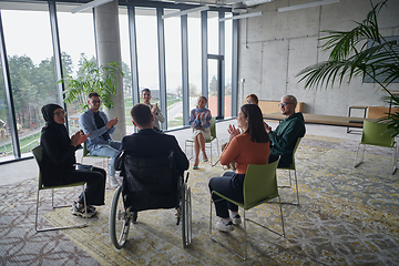 Image showing In a modern office, a diverse group of business individuals is seen gathered in a circle, engaged in lively discussions and sharing ideas about various business concepts.