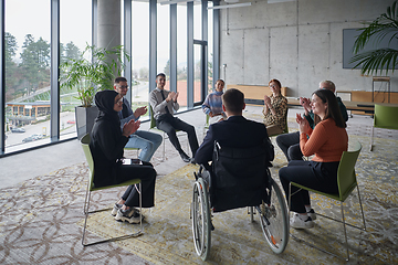 Image showing In a modern office, a diverse group of business individuals is seen gathered in a circle, engaged in lively discussions and sharing ideas about various business concepts.