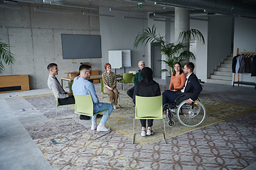 Image showing In a modern office, a diverse group of business individuals is seen gathered in a circle, engaged in lively discussions and sharing ideas about various business concepts.