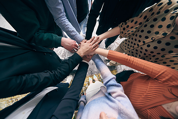 Image showing A top view photo of group of businessmen holding hands together to symbolize unity and strength