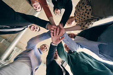 Image showing A group of businessmen holding hands together to symbolize unity and strength