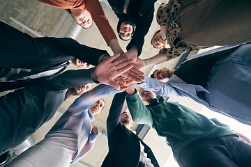 Image showing A group of businessmen holding hands together to symbolize unity and strength