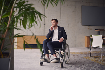 Image showing A melancholic businessman in a wheelchair sitting with a sad expression, gazing through the window of a modern office, conveying a sense of solitude