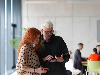 Image showing In a modern and spacious office a team of business colleagues are seen diligently working together, using a laptop to analyze data and statistics