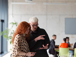 Image showing In a modern and spacious office a team of business colleagues are seen diligently working together, using a laptop to analyze data and statistics