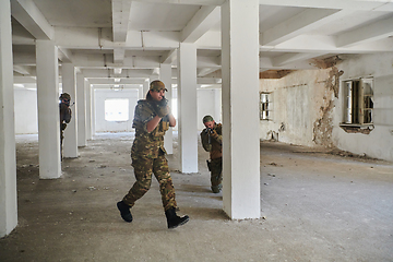 Image showing A group of professional soldiers bravely executes a dangerous rescue mission, surrounded by fire in a perilous building.