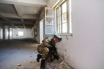 Image showing A professional soldier carries out a dangerous military mission in an abandoned building