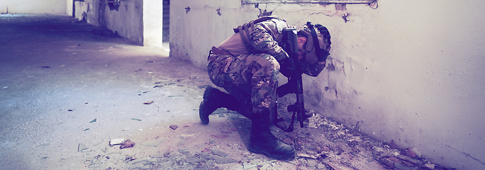 Image showing A professional soldier carries out a dangerous military mission in an abandoned building