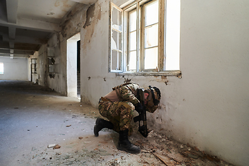 Image showing A professional soldier carries out a dangerous military mission in an abandoned building