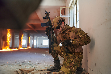 Image showing Soldier in action near window changing magazine and take cover