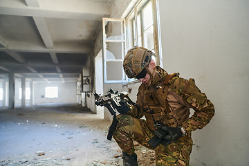 Image showing Soldier in action near window changing magazine and take cover