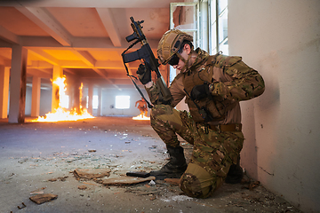 Image showing Soldier in action near window changing magazine and take cover