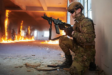 Image showing Soldier in action near window changing magazine and take cover