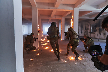 Image showing A professional cameraman captures the intense moments as a group of skilled soldiers embarks on a dangerous mission inside an abandoned building, their actions filled with suspense and bravery