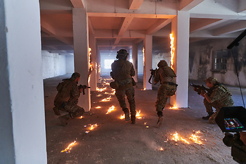 Image showing A professional cameraman captures the intense moments as a group of skilled soldiers embarks on a dangerous mission inside an abandoned building, their actions filled with suspense and bravery