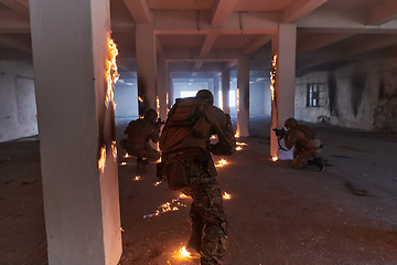 Image showing A group of professional soldiers bravely executes a dangerous rescue mission, surrounded by fire in a perilous building.