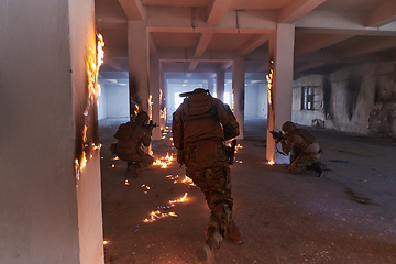 Image showing A group of professional soldiers bravely executes a dangerous rescue mission, surrounded by fire in a perilous building.