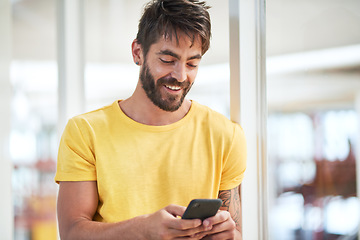 Image showing A small gadget that gives you a big edge. a young businessman using a smartphone in a modern office.