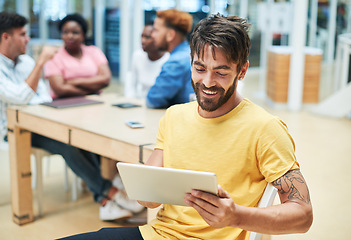 Image showing Managing meetings has never been more simpler. a young businessman using a digital tablet during a team meeting in a modern office.