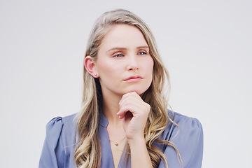 Image showing Ive been doing some thinking about this...Studio shot of a young woman looking thoughtful against a gray background.